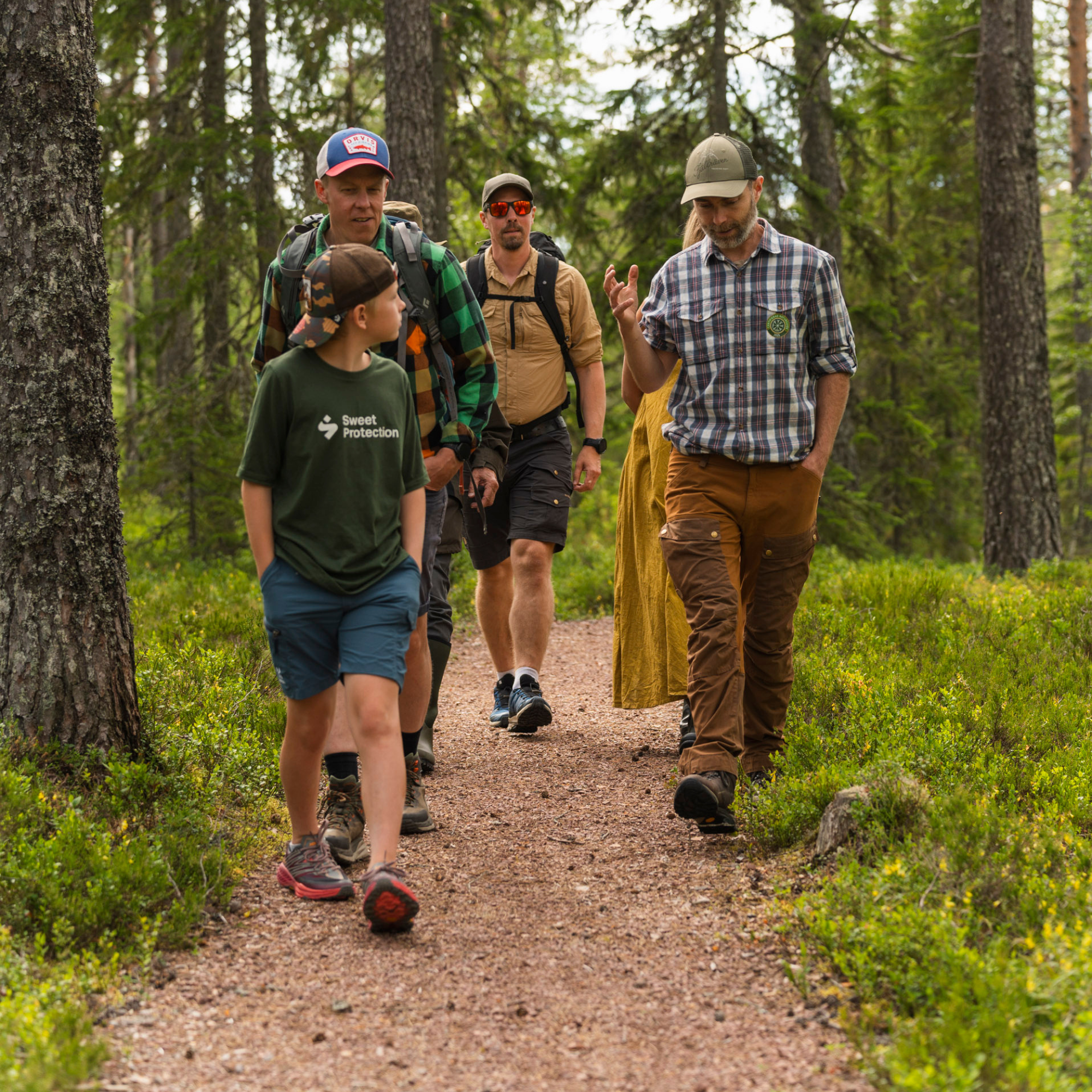 Personer som vandrar på en stig i skogen.
